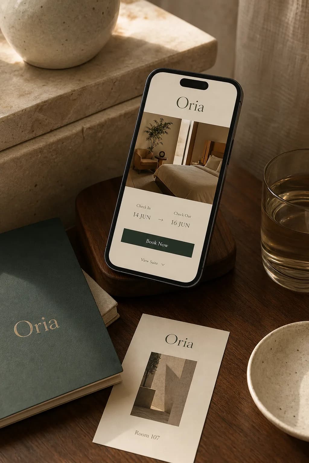 Composition de réservation mobile Oria sur bois, pierre et supports de marque fictifs — illustration originale du concept Oria House (projet fictif).